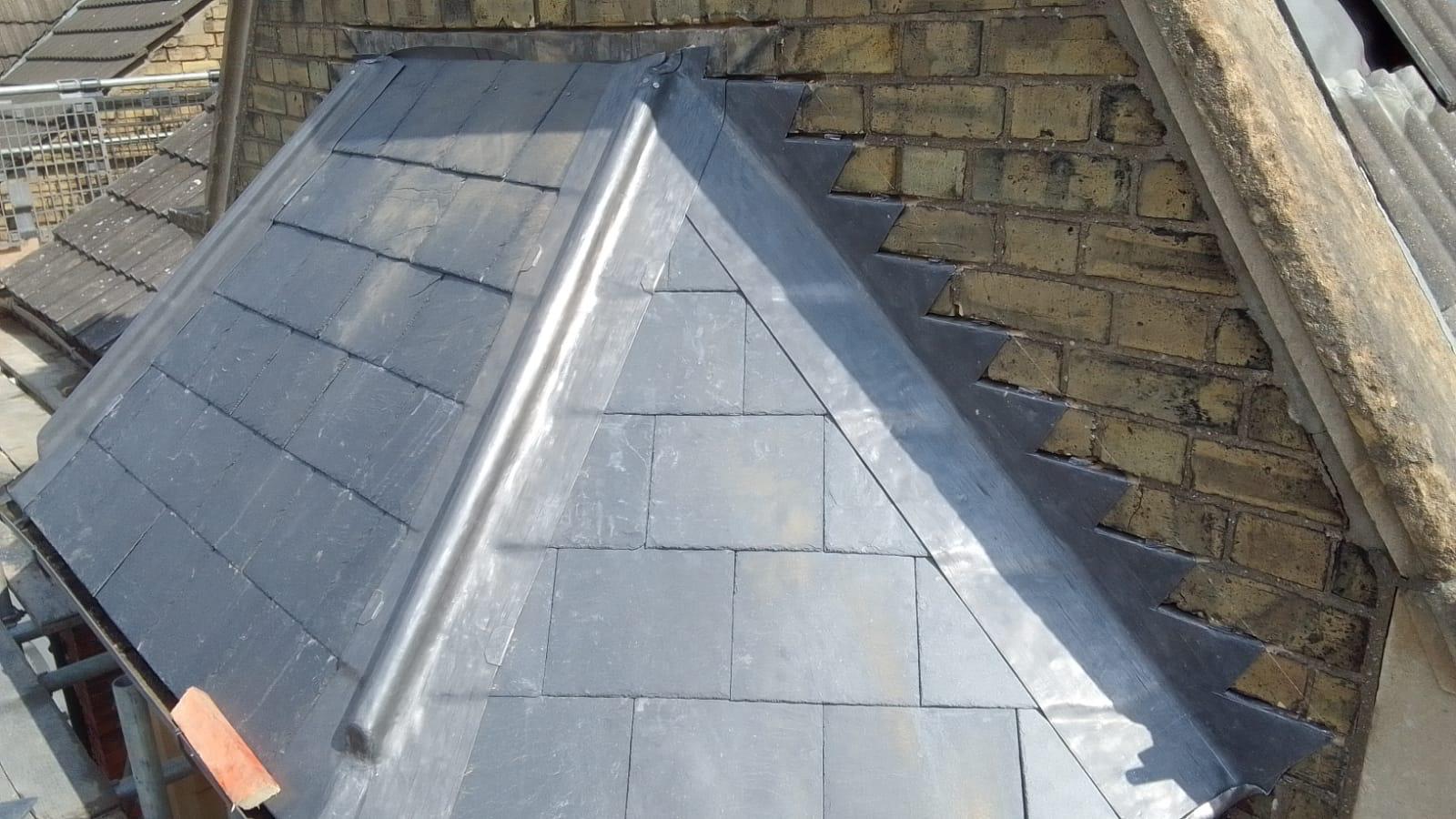 close up of a slate roof with precise, geometric tiles and detailed lead flashing against a brick wall. the scene conveys craftsmanship and durability close up of a slate roof with precise, geometric tiles and detailed lead flashing against a brick wall. the scene conveys craftsmanship and durability